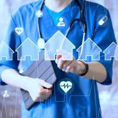 Doctor holding a tablet and pointing at home icon